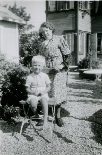 Olga Axén och brorsonen Bengt Axén (född 1942) vid Angarns café.  Olga var syster till Seth Axén. Detta är uteserveringen innan ombyggnad, till vänster skymtar paviljongen belägen i serveringen. Serveringen omgärdades av en härlig syrenhäck. En pump syns till höger. 
Begsättra i Angarn med café och Shell bensinstation drevs av Seth Abel Axén (levde 1899-1986) tillsammans med hustrun Ruth (1904-2003) samt systern Olga Axén (död 1951). Seth började med en kiosk på 1930-talet. 1947 byggdes fastigheten om.