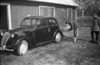 Bo Sundmark tvättar bilen på Ekskogens gård. Nils Sundmark tittar på.