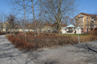 Kommunalhusparken i Vallentuna centrum med scenen till höger i bild. I bakgrunden till höger syns hus vid Allévägen. Till vänster skymtar det gamla polishuset som revs 2021 för att lämna plats åt ett nytt hus med studentbostäder.
