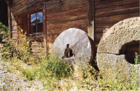 Två gamla kvarnstenar står lutade mot en fasad på Husby gård. Mangårdsbyggnaden på Husby gård hyser ett gårdsmuseum. Patron Gustafsons hem och samlingar utgör stommen i museet. 