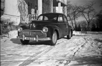 En Peugeot 203 står parkerad framför huvudingången till Ekskogens gård. Sparkstöttingen till vänster tillhörde Inez Ekholm som ägde gården tillsammans med Manfred Ekholm. Cykeln till höger var fotografens. Uppgift om fotoår saknas men troligen mitten av 1950-talet.
