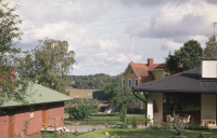 Vy över Trekanten från Skolvägen. Området Trekanten begränsas av vägarna Olsborgsvägen, Karlbergsvägen och Skolvägen. Längst bak till höger syns "Villa Framnäs" med gul fasad, byggår 1910 och till höger en 1970-talsvilla.