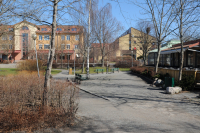 Kommunalhusparken i Vallentuna centrum. I bakgrunden skymtar hus vid Allévägen, förvaltningshuset Tärningen syns längst bort till höger. Närmast till höger restaurang Vallentuna Gästgiveri "Gästis Kök & Bar".
