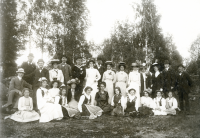 Längst till höger står handlaren Ferdinand Lindström. Tvåa från vänster längst bak är handlaren Carl Bornholm (1882-1931) i kubb och fluga bredvid en dam i vit blus och stor hatt. Längst ner till vänster sittande i vit klänning är Ferdinand Lindströms dotter Edit född 1897, som senare blev lärare i Hjälmsta skola. Möjligen kan detta vara ett foto från en sommarfest med Vallentuna skytteförening där de båda namngivna herrarna var medlemmar.