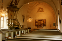 Frösunda kyrka, interiör. I kyrkan finns ett medeltida altarskåp, en dopfunt från 1100-talet och en sengotisk ljuskrona.