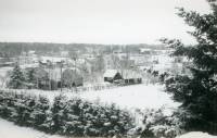 Utsikt från villa Marieborg i centrala Vallentuna på vintern med snötäcke. Vid fotot står skrivet "Vallentunas lilla centrum innan nybebyggelse". Hjälmsta skola längst bort till höger. Det höga vita huset mitt i bild är Tibells affär.