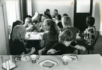 Össeby-Garns skola, dokumenterad en av de sista dagarna innan skolverksamheten läggs ner. Eleverna äter skollunch som serveras i f.d Össeby kommuns kommunalkontor. 
•Fotografiet ingår i bildserien ”Vardagsliv i Vallentuna kommun” av Rachael Gough-Azmier & Gunilla Blomé, Haga Studios HB.