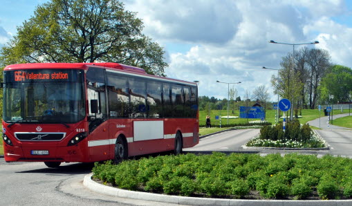 Röd buss som kör in i rondellen.