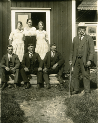 Bakre raden från vänster, Mia Bergqvist, okänd, Rosa Bergqvist. Främre raden, Simon Bergqvist, okänd, Isidor Bergqvist och fadern Algot Bergqvist på trappen till gamla stugan i Gunby.