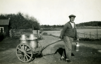 Hugo Bergqvist från Gunby, Össeby-Garn drar två mjölkkannor på en kärra. Hugo arbetade på olika gårdar i Uppland. Foto från 1930-1940-talet.