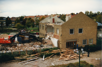 Rivning av gamla kommunalhuset sett från Tunahuset. Grävskopan sätter tänderna i norra flygeln.