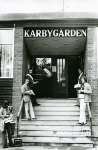 Utanför vallokalen i Karbyskolans matsal i Brottby. Partifunktionärer från olika partier står på trappan utanför entrén till Karbygården för att dela ut sina valsedlar.
•Fotografiet ingår i bildserien ”Vardagsliv i Vallentuna kommun” av Rachael Gough-Azmier & Gunilla Blomé, Haga Studios HB.