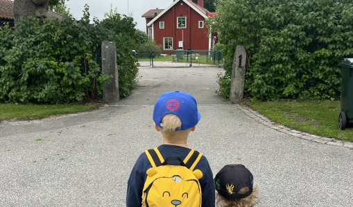 Två barn som tittar mot ingången till förskola.