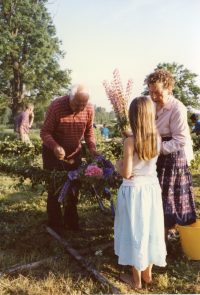 Midsommarstången på Kyrkängen i Vallentuna förbereds kvällen innan midsommarafton. Anna-Brita Dahl, längst till höger, binder blomsterkransar som bland annat innehåller blå och rosa lupiner.