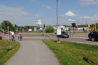 Biltrafik och cyklister vid järnvägskorsningen söder om Vallentuna station. Korsningen kallades i folkmun för ”Röda korset” eftersom det ofta blev stopp och långa köer. Korsningen ersattes av en planskild korsning med järnvägsbro som stod klar runt 2013. 