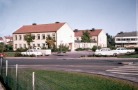 Kommunallhuset. I förgrunden går Skördevägens infart från Banvägen, i bakgrunden till höger syns Torghuset med bibliotekets skylt på fasaden.