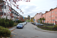 Centralvägen, Vallentunas första affärsgata, med bostäder och affärslokaler som byggdes i början av 1950-talet. Vy från Tuna torg upp mot Vallentuna kyrka. Till höger går Skördevägen.