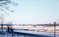 Vy från Skolvägen / Hjälmsta skola ner mot Vallentunasjön. En buss kör längs Stockholmsvägen.