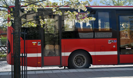 Bakdelen av en buss som står parkerad intill en väg.