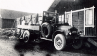 Lastbil med mjölkflaskor på flaket utanför mejeriet vid Husbygård i Markim, Det kan vara åkaren Sven Andersson som kör bilen.